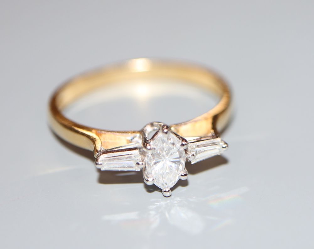 A modern 18ct gold, marquise and trapeze cut diamond set three stone dress ring, size Q, gross 3.1 grams,